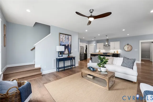 a living room with furniture kitchen view and a chandelier