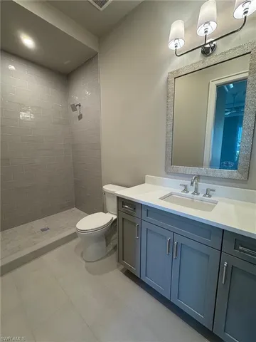 a bathroom with a granite countertop toilet a sink and a mirror
