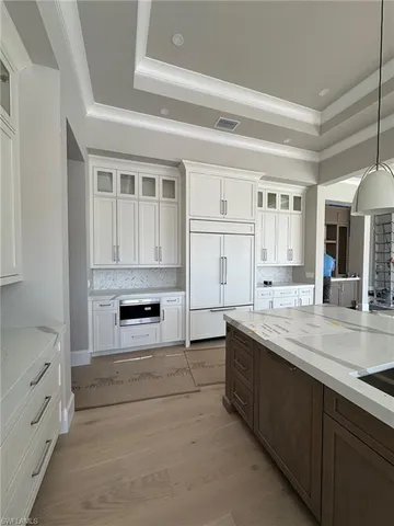 a kitchen with granite countertop white cabinets and white appliances