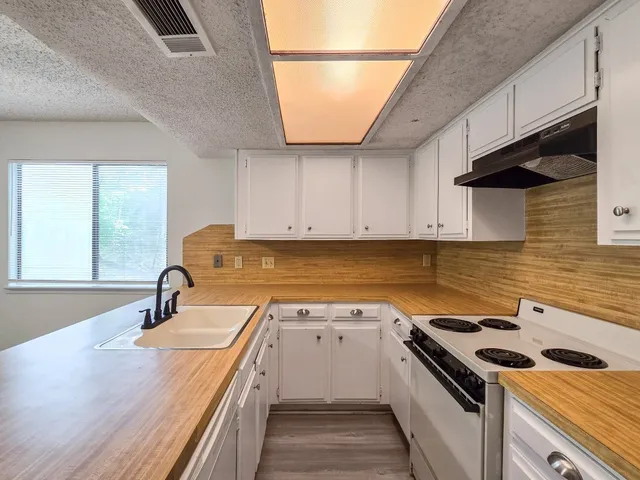 a kitchen with granite countertop a sink stainless steel appliances and cabinets