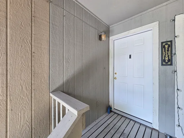 a view of empty room with window and wooden floor