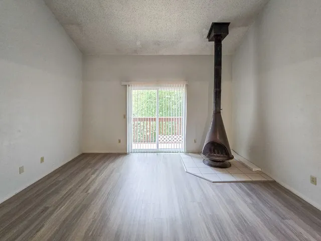 a view of empty room with wooden floor and lamp