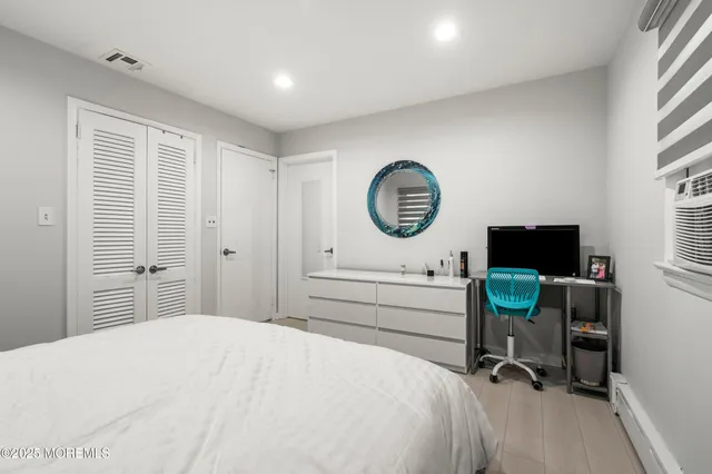 a bedroom with a bed a chair and a large window