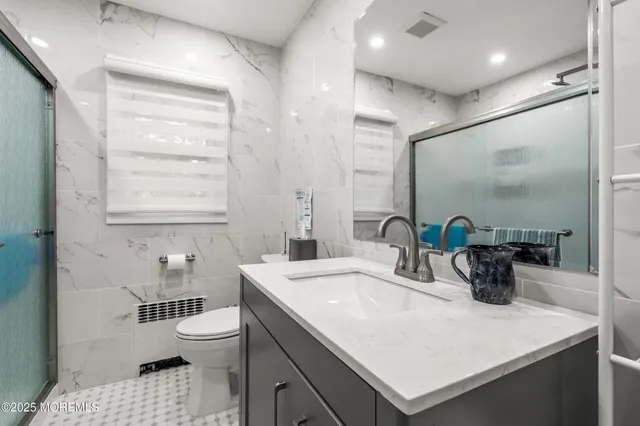 a bathroom with a sink a toilet and a mirror