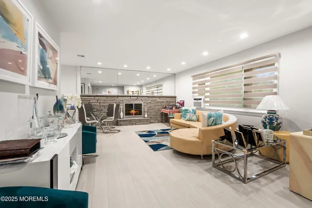 a living room with furniture kitchen view and a large window