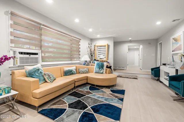 a living room with fireplace furniture and a large window