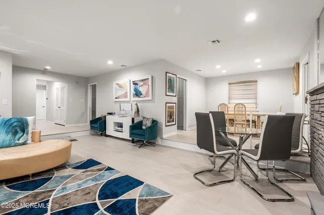 a living room with furniture and a dining table with kitchen view