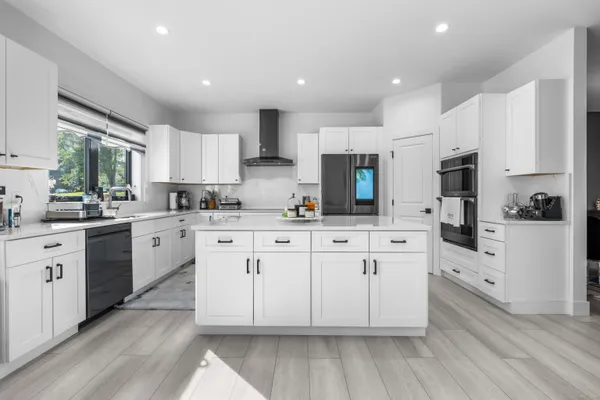 a kitchen with cabinets stainless steel appliances a sink and a window
