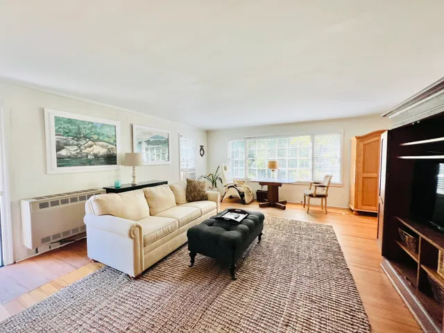a living room with furniture a rug and a flat screen tv