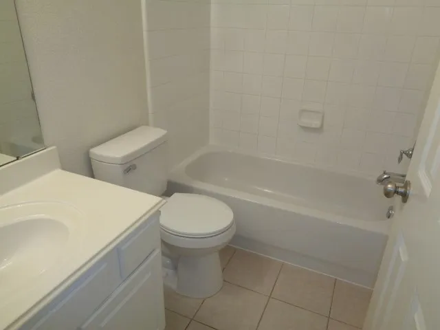 a white toilet sitting next to a bath tub