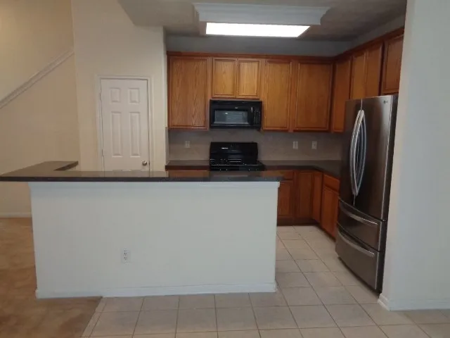 a kitchen with stainless steel appliances a refrigerator and a stove top oven