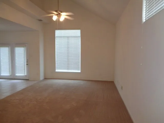 an empty room with windows and fan