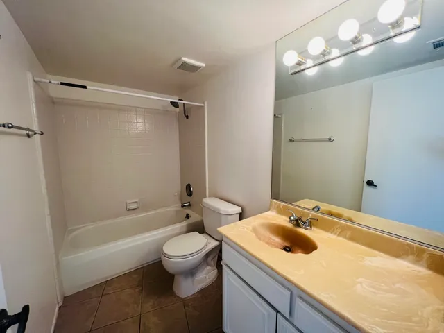 a bathroom with a sink vanity granite tub and a mirror
