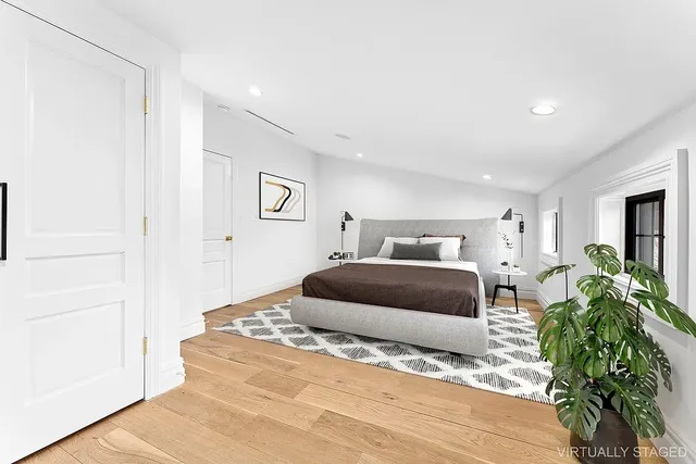 a bedroom with a bed and a potted plant