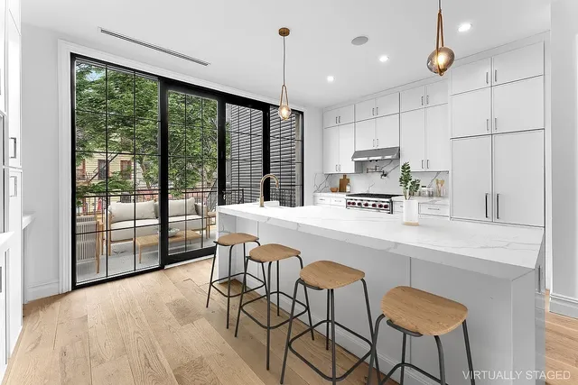 a kitchen with stainless steel appliances granite countertop a stove a sink dishwasher a dining table and chairs with wooden floor