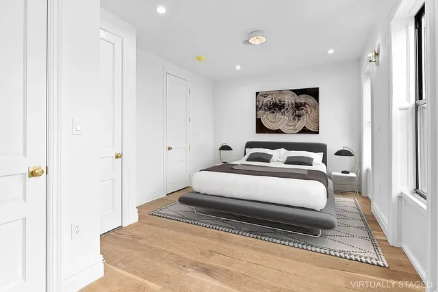 a spacious bedroom with a bed and a painting on the wall