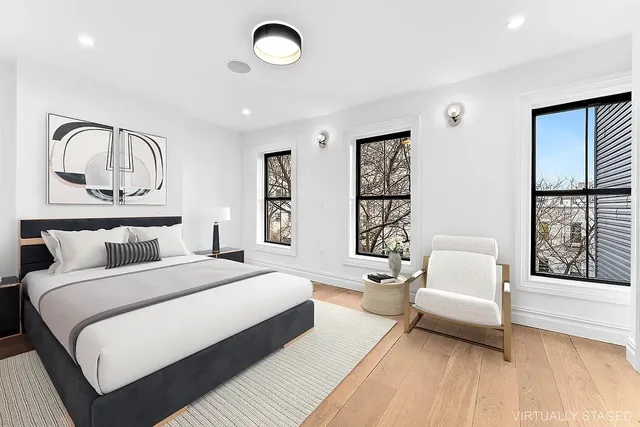 a spacious bedroom with a bed a couch and a window