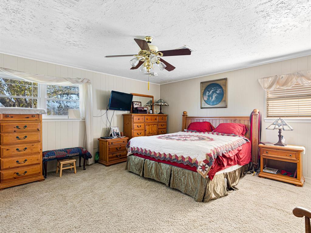 117 County Road 2646 Decatur, TX 76234 - Photo 19 of 39 a bedroom with a bed and a chandelier