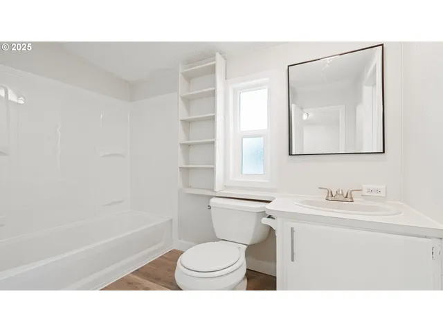 a bathroom with a sink tub vanity and a toilet