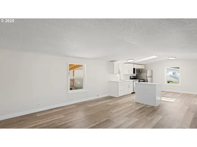a kitchen with cabinets and wooden floor