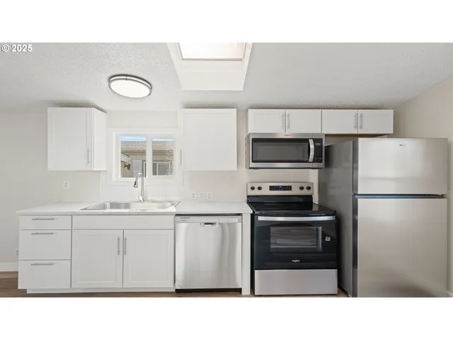 a kitchen with a sink stainless steel appliances and cabinets