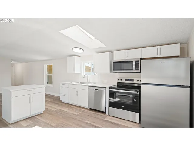 a kitchen with white cabinets and stainless steel appliances