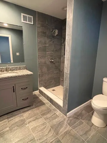 a bathroom with a sink a toilet and shower