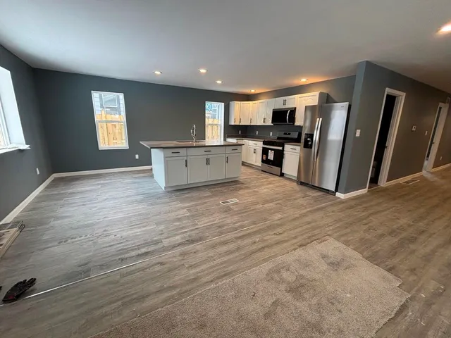 a view of kitchen with refrigerator microwave and stove