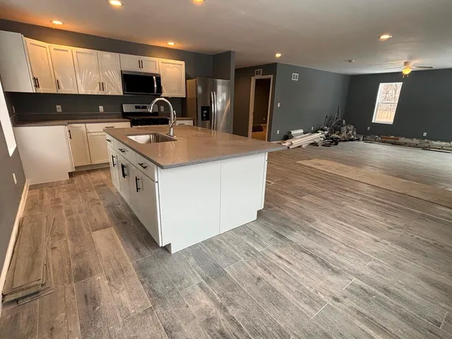 a kitchen with stainless steel appliances a stove top oven a sink dishwasher and a refrigerator