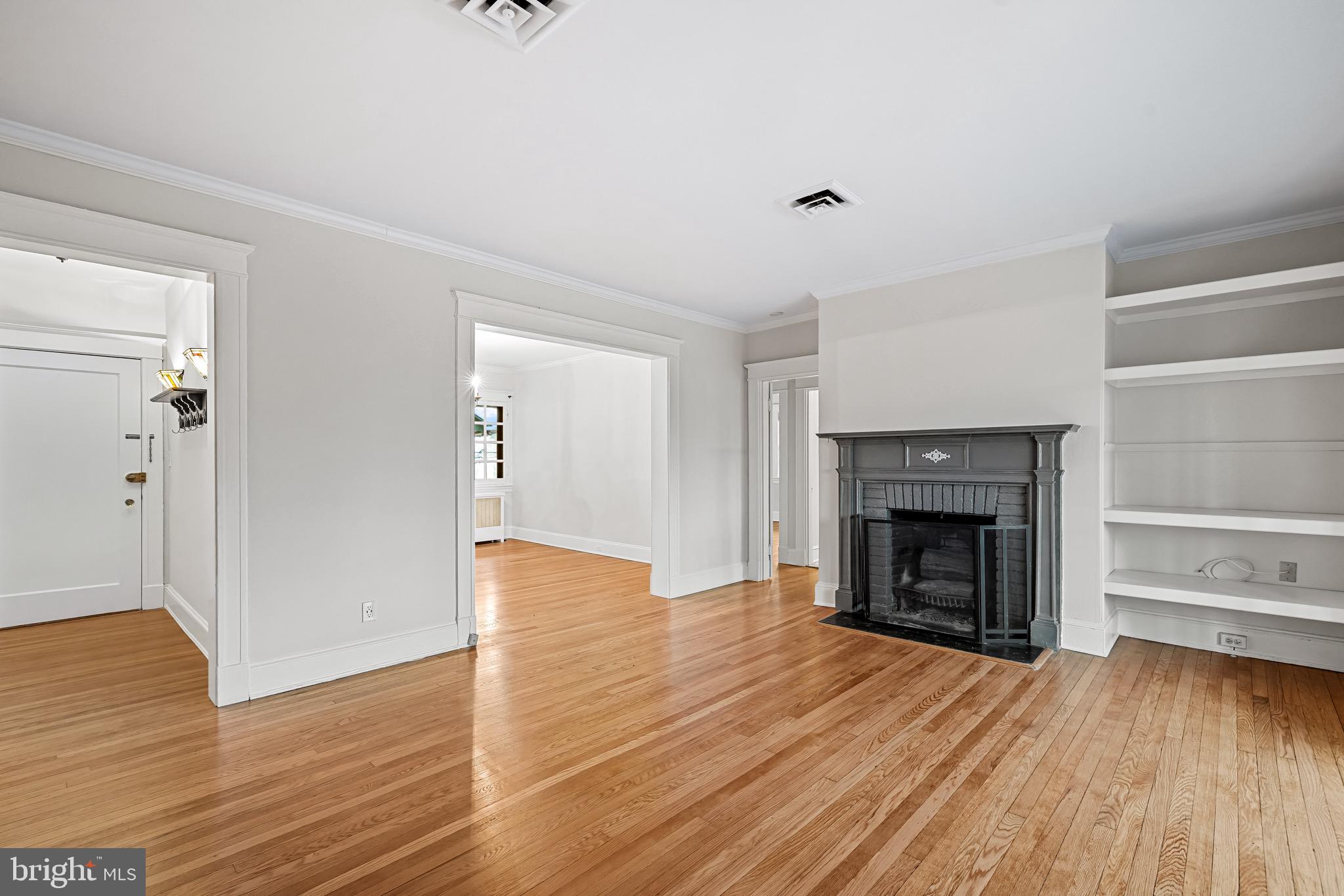 4300 Roland Avenue, Unit 302 Baltimore, MD 21210 - Photo 2 of 43 a view of an empty room with wooden floor fireplace and a window