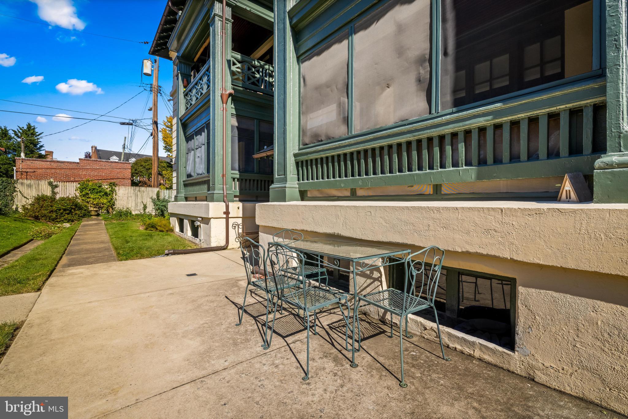 4300 Roland Avenue, Unit 302 Baltimore, MD 21210 - Photo 35 of 43 a view of a patio with table and chairs a barbeque with wooden floor and fence