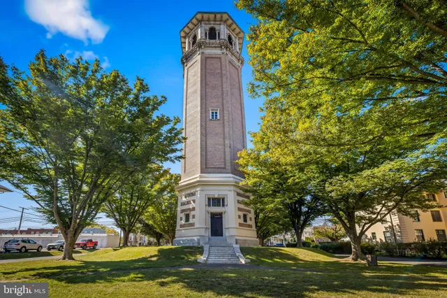 a front view of a house with a garden and trees