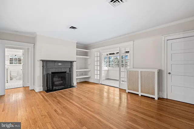 a view of empty room with wooden floor and fireplace