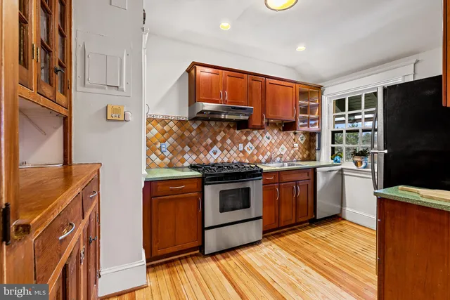 a kitchen with stainless steel appliances granite countertop a stove and a refrigerator