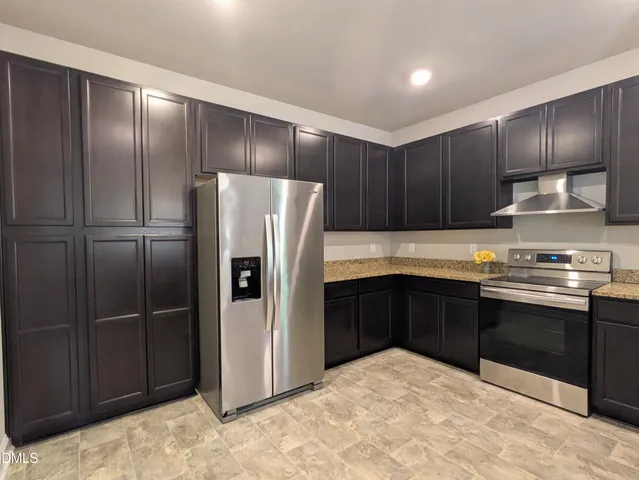 a kitchen with stainless steel appliances granite countertop a refrigerator and a sink