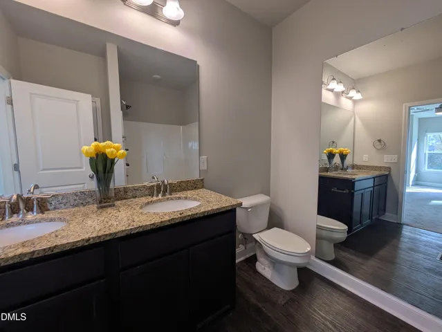 a bathroom with a granite countertop toilet sink and mirror