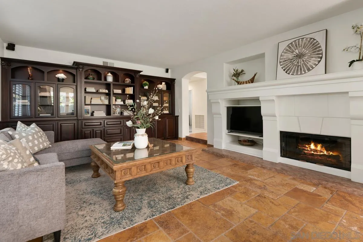4889 Riding Ridge Road San Diego, CA 92130 - Photo 13 of 34 a living room with furniture a fireplace and a flat screen tv