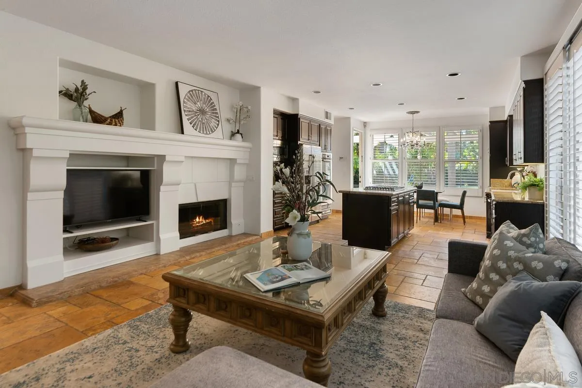 4889 Riding Ridge Road San Diego, CA 92130 - Photo 14 of 34 a living room with furniture a table and a fireplace