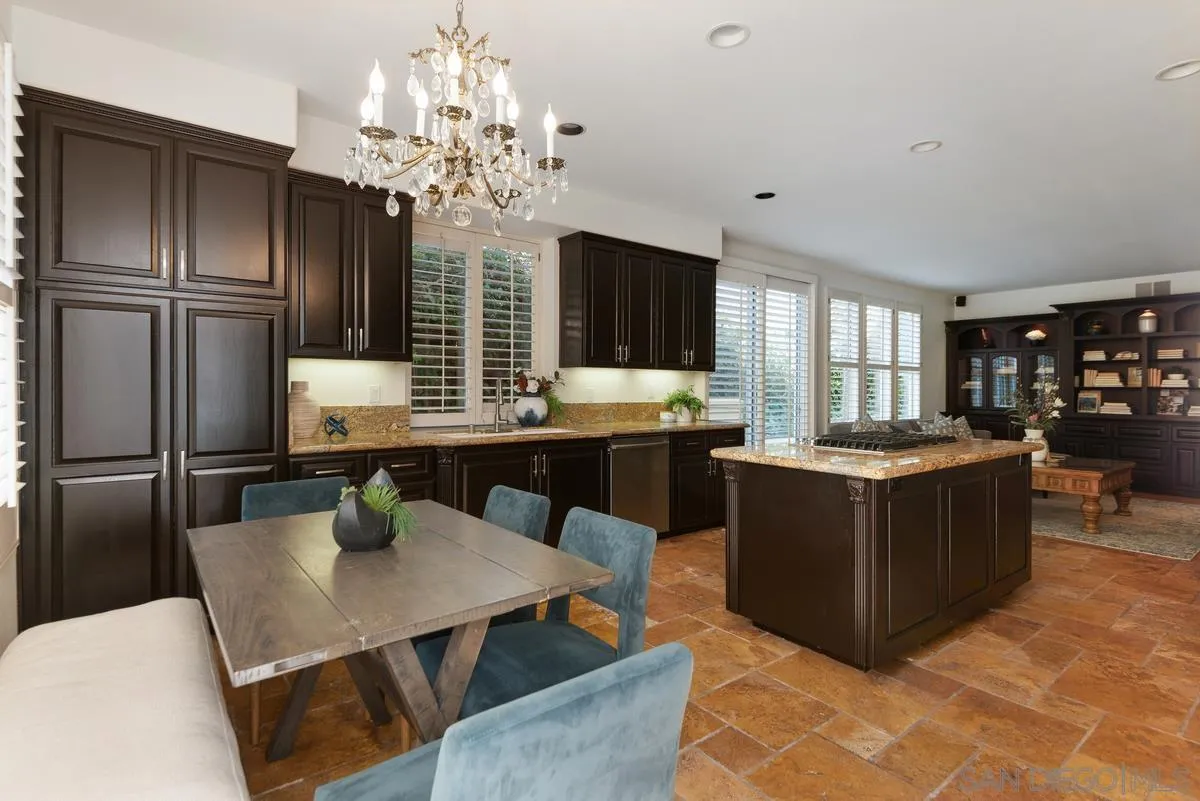 4889 Riding Ridge Road San Diego, CA 92130 - Photo 18 of 34 a kitchen with a chandelier stainless steel appliances a sink and living room view