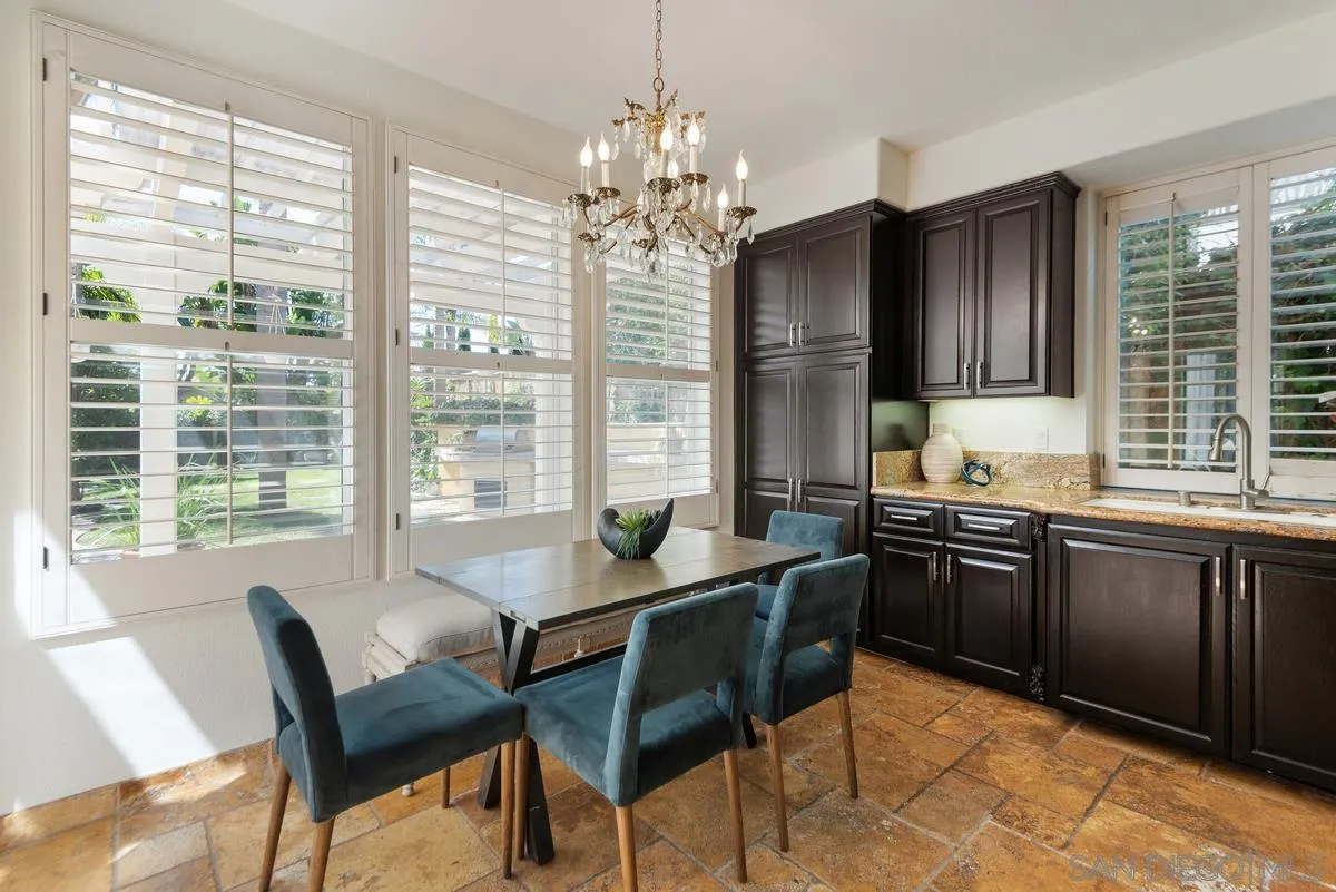 4889 Riding Ridge Road San Diego, CA 92130 - Photo 19 of 34 a kitchen with granite countertop wooden cabinets dining table and chairs