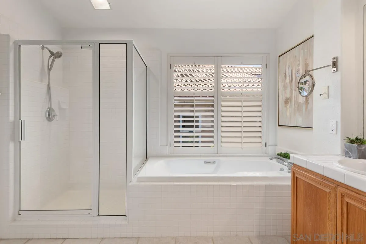 4889 Riding Ridge Road San Diego, CA 92130 - Photo 25 of 34 a bathroom with a bathtub and a shower