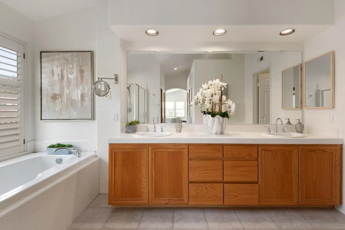 4889 Riding Ridge Road San Diego, CA 92130 - Photo 26 of 34 a bathroom with a tub sink and mirror