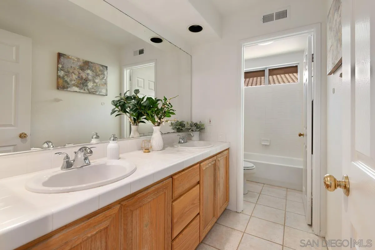 4889 Riding Ridge Road San Diego, CA 92130 - Photo 28 of 34 a bathroom with a sink and a mirror