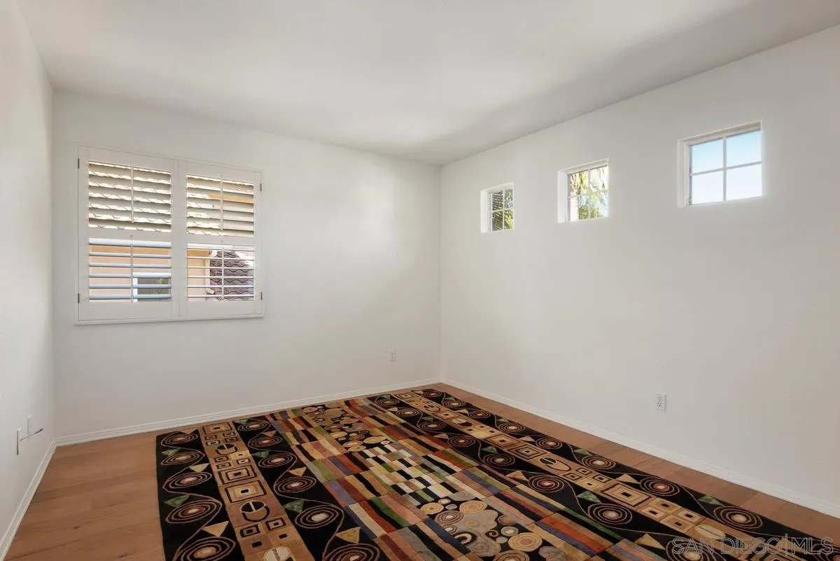 4889 Riding Ridge Road San Diego, CA 92130 - Photo 30 of 34 a view of a room with wooden floor and fan