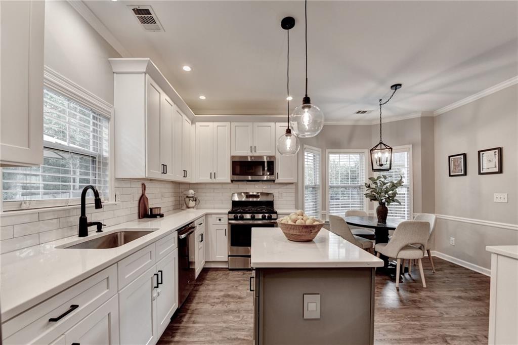 1130 Rome Drive Roswell, GA 30075 - Photo 31 of 96 a kitchen with stainless steel appliances kitchen island granite countertop a sink a stove and a center island