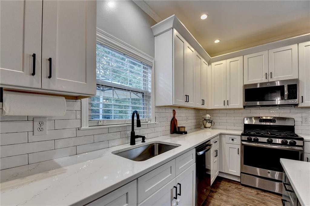 1130 Rome Drive Roswell, GA 30075 - Photo 33 of 96 a kitchen with stainless steel appliances a sink a stove and cabinets