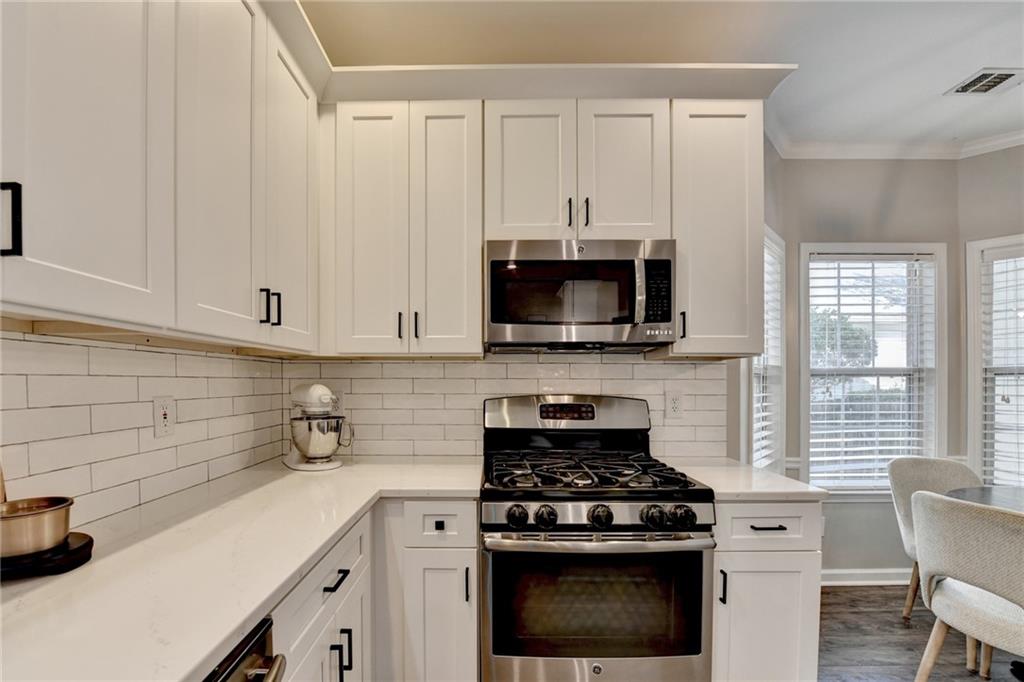 1130 Rome Drive Roswell, GA 30075 - Photo 41 of 96 a kitchen with stainless steel appliances a white stove top oven and white cabinets