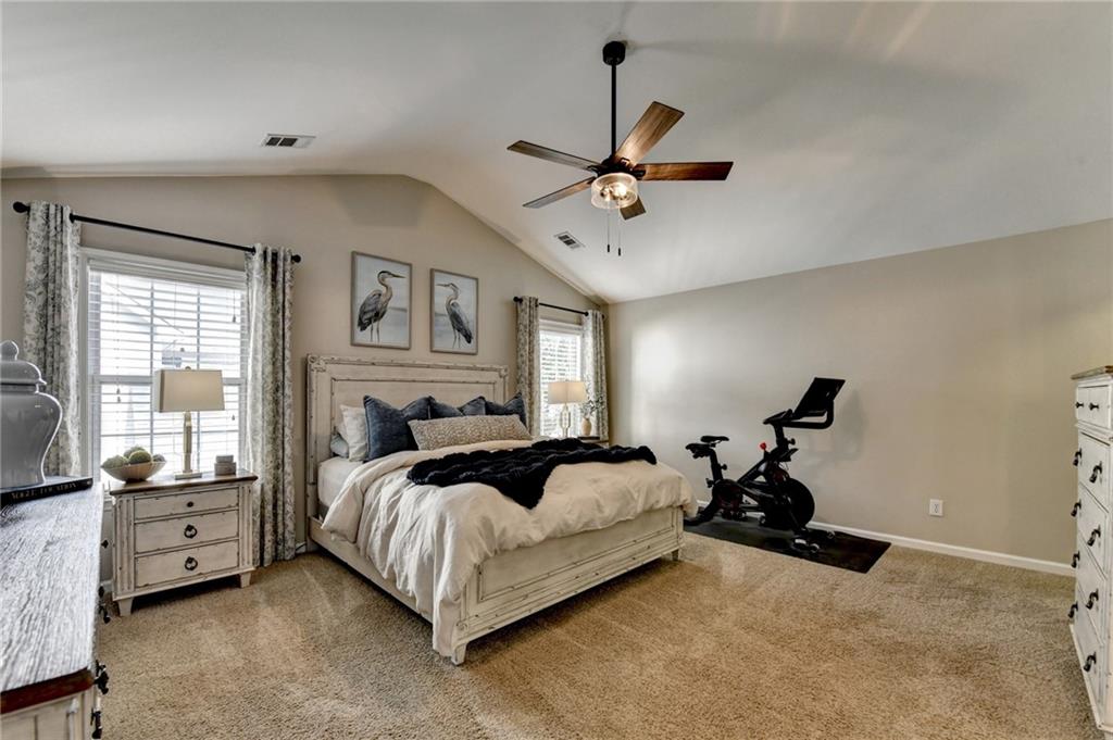 1130 Rome Drive Roswell, GA 30075 - Photo 48 of 96 a spacious bedroom with a bed and a chandelier