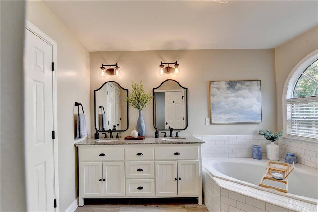 1130 Rome Drive Roswell, GA 30075 - Photo 60 of 96 a bathroom with a double vanity sink and a bathtub