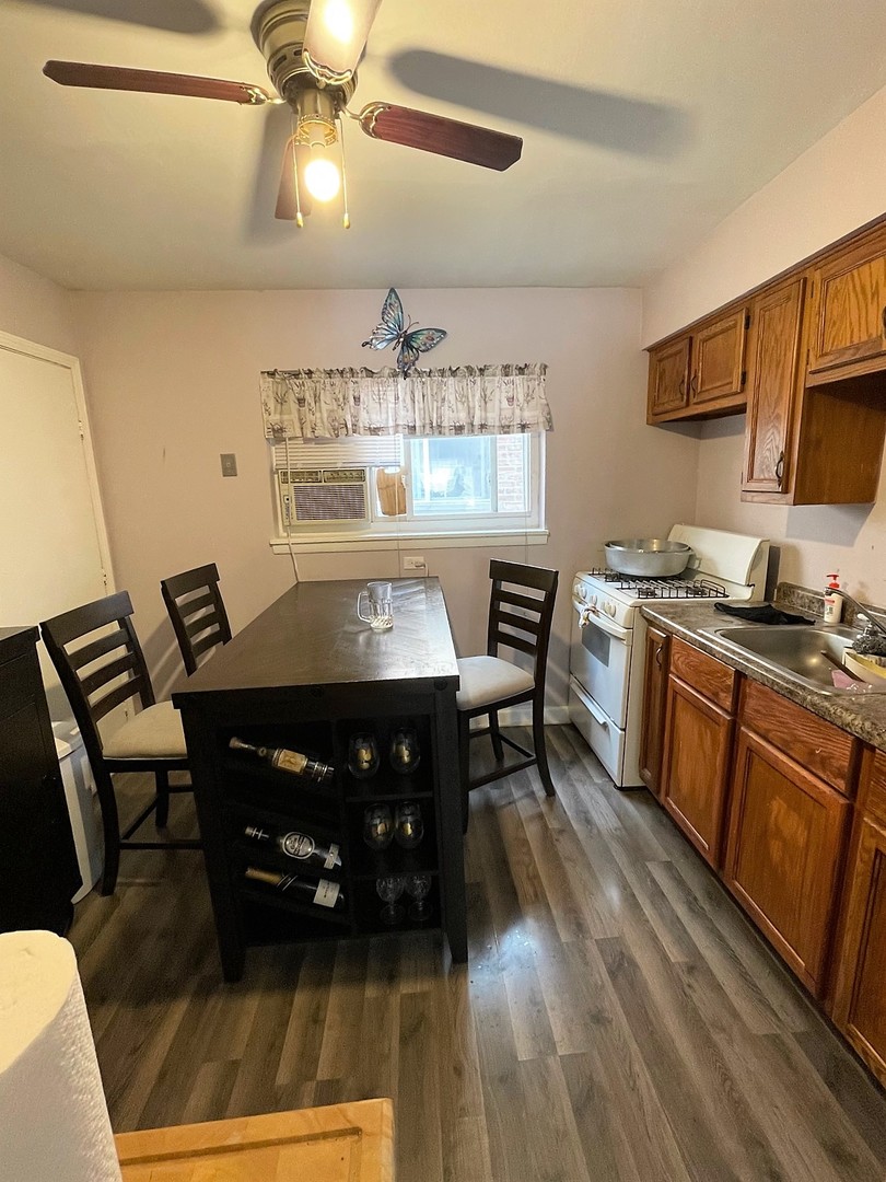 7240 Park Avenue Summit, IL 60501 - Photo 5 of 12 a view of a dining room with furniture a kitchen and chandelier fan